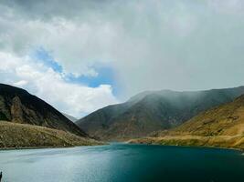 a river runs through a valley surrounded by mountains photo