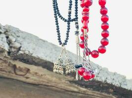 a necklace with red beads hanging from a wall photo