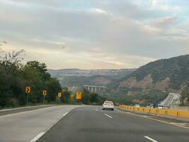 a car driving down the highway with mountains in the background photo