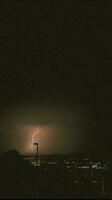 a lightning bolt is seen over a city at night photo