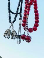 a necklace with red beads hanging from a wall photo