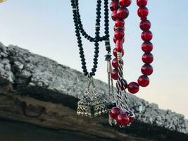 a necklace with red beads hanging from a wall photo