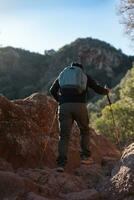 Middle-aged man climbs the mountain in the Garraf Natural Park, supported by hiking poles. photo