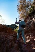 Woman climbs the mountain in the Garraf Natural Park, supported by hiking sticks. photo