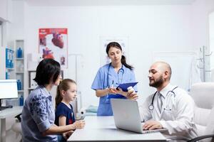 Doctor holding pills bottle during child consultation in home office. . Healthcare physician specialist in medicine providing health care services treatment examination. photo