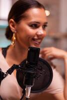 Smiling young woman making podcast recording for online show in home studio. Creative online show On-air production internet broadcast host streaming live content, recording digital social media photo