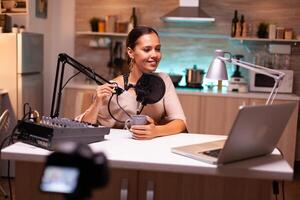 Social media analyst speaking on microphone during podcast with neon light in the background, recording. Online show On-air production internet broadcast host streaming live content. photo