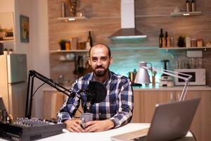 Influencer holding coffee cup and recording podcast in home studio. Creative online show On-air production internet broadcast host streaming live content, recording digital social media communication photo