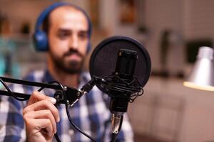 Blogger wearing headphones and talking about lifestyle during podcast Creative online show On-air production internet broadcast host streaming live content recording digital social media communication photo