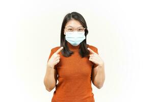 Wearing Medical Mask for Preventing Corona Virus and Pointing to Mask Of Beautiful Asian Woman photo