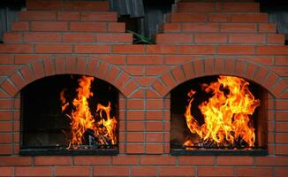 madera registros ardiente en un doble ladrillo horno foto