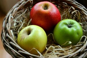 Yellow, Red And Green Apple Fruits In Wood Swarf In A Wicker Pot Closeup Stock Photo