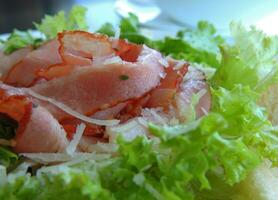 Pork Ham On A Plate With Green Lettuce Leaves Macro Shot photo