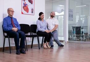 estresado casado Pareja llorando en hospital esperando zona después malo Noticias desde médico en virus prueba resultados. mujer escuchando desfavorable noticias, mientras mayor hombre esperando a Vamos en examen habitación. foto