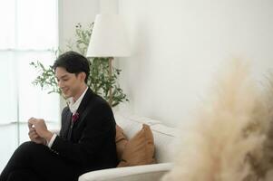 Portrait of young handsome groom in suit, preparing for wedding ceremony photo