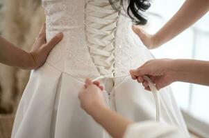 Close up of tying bow on elegant White bridal wedding dress photo