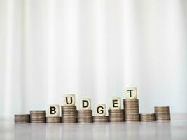 Wooden blocks with the word BUDGET on stack of coins. The concept about budget planning and allocation photo