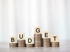 Wooden blocks with the word BUDGET on stack of coins. The concept about budget planning and allocation photo