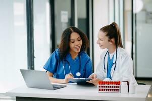 Doctor Talks With Professional Head Nurse or Surgeon, They Use Digital tablet Computer. Diverse Team of Health Care Specialists Discussing Test Result photo