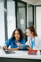 Doctor Talks With Professional Head Nurse or Surgeon, They Use Digital tablet Computer. Diverse Team of Health Care Specialists Discussing Test Result photo