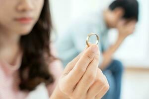 divorcio. la mujer quita el anillo casado. parejas desesperadas y decepcionadas después del matrimonio. esposo esposa triste, molesto y frustrado después de un conflicto de peleas. desconfianza, problemas de amor, traiciones, familia, amante foto