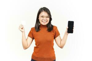 Holding Blank Bank Card and Smartphone With Blank Screen Of Beautiful Asian Woman Isolated On White photo