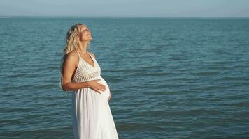 A pregnant woman walks along the coast of the sea and enjoys. video