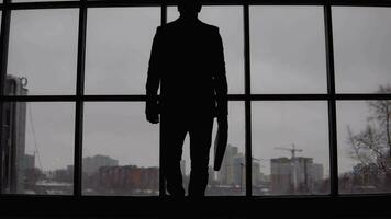 Business and finance. businessman approaches and leans on the window in the office video