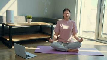 Happy woman meditating at home using laptop. video