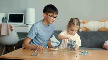 niños jugar con un metal constructor a el mesa a hogar. video