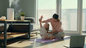 mamma och dotter do morgon- övningar på Hem på de golv nära de fönster. video