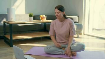 feliz mulher meditando às casa usando computador portátil. video