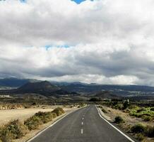 an empty road in the middle of a desert photo