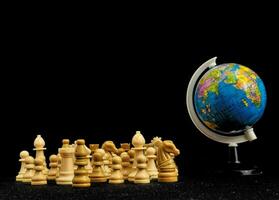 a globe and chess pieces on a black background photo