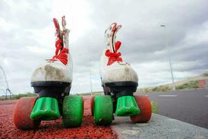 two roller skates with green and red wheels photo