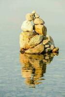 a stack of rocks in the water photo