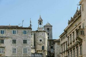 a clock tower in the middle of a city street photo