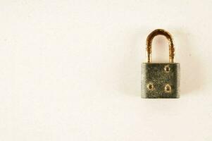 an old padlock on a white wall photo