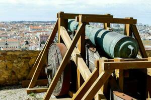 a cannon on top of a wooden platform overlooking a city photo