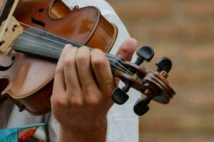 un cerca arriba de un persona jugando un violín foto