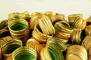 a pile of gold and green plastic bottle caps photo