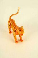 a toy tiger on a white surface photo