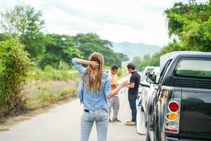 Back view of woman waiting her husband with car slide after car accidents on road side. Traffic accident insurance concept photo