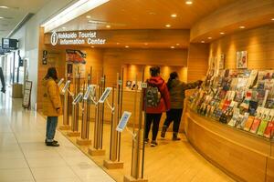 Sapporo City, Japan, 2018 - Chinese tourists pick up a information guide books and attractions map at Hokkaido Tourist Information Center in New Chitose Airport, Japan. photo