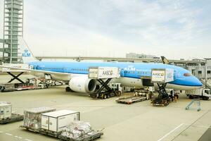 Osaka ciudad, Japón, 2018 - azul avión de klm real holandés aerolínea llegando a Kansai internacional aeropuerto, Japón con cargando equipaje y viajeros desde el avión a el Terminal. foto