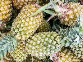 Closeup and crop heap of pineapple in the market. photo