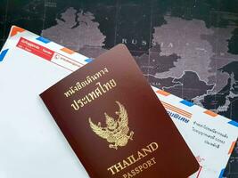 Bangkok ciudad, tailandia, 2018 -tailandés pasaporte libro en sobre y mundo mapa antecedentes. foto