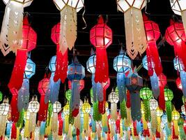 de cerca y Mira arriba ver vistoso de tailandés lanna estilo linternas a colgar en frente de el templo en noche hora en loy kratong festival. foto