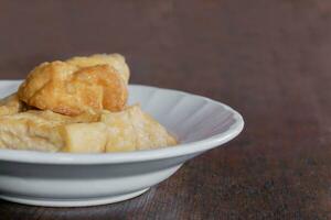 Closeup and crop Chinese snack and vegetarian food on white ceramic plate and wooden table background. photo