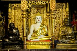 Ancient golden Buddha statue of Burmese art in sanctuary at Wat Phra That Hariphunchai Lumphun Thialand. photo